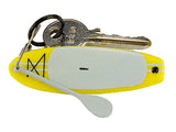 Keychain with a yellow miniature stand up paddleboard and keys on a white background